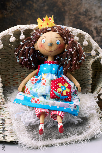 Handmade fabric doll with colorful dress, curly hair, and crown