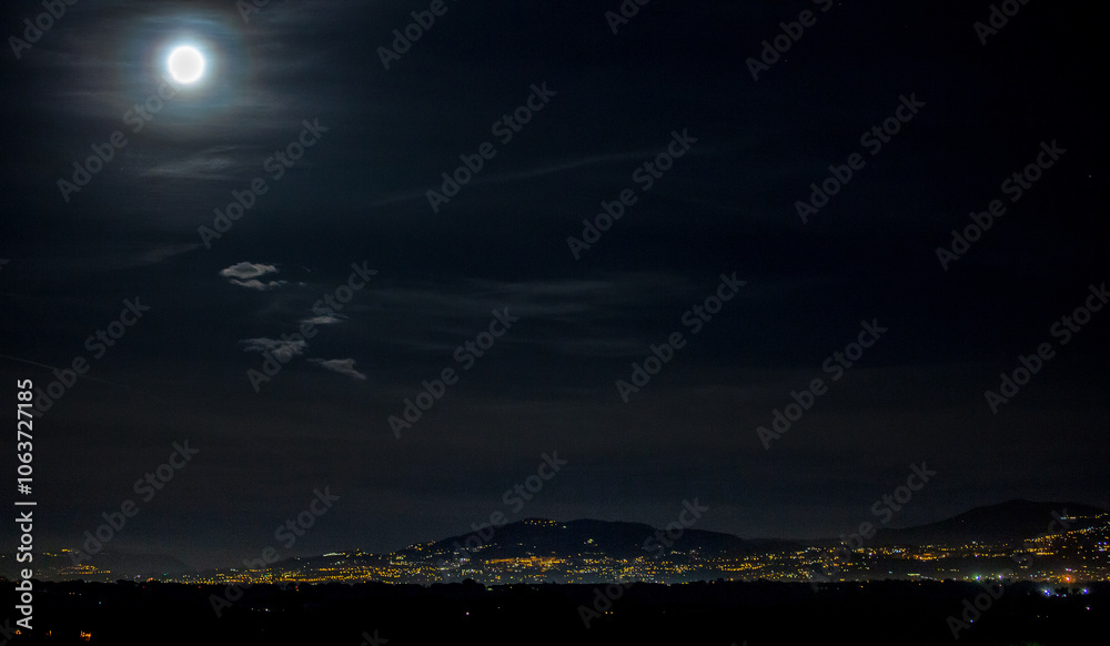 Summer full moon with the lights of the Castelli Romani in background
