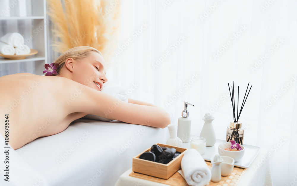 Caucasian woman customer enjoying relaxing anti-stress spa massage and pampering with beauty skin recreation leisure in day light ambient salon spa at luxury resort or hotel. Quiescent Caucasian woman customer enjoying relaxing anti-stress spa massage and pampering with beauty skin recreation leisure in day light ambient salon spa at luxury resort or hotel. Quiescent