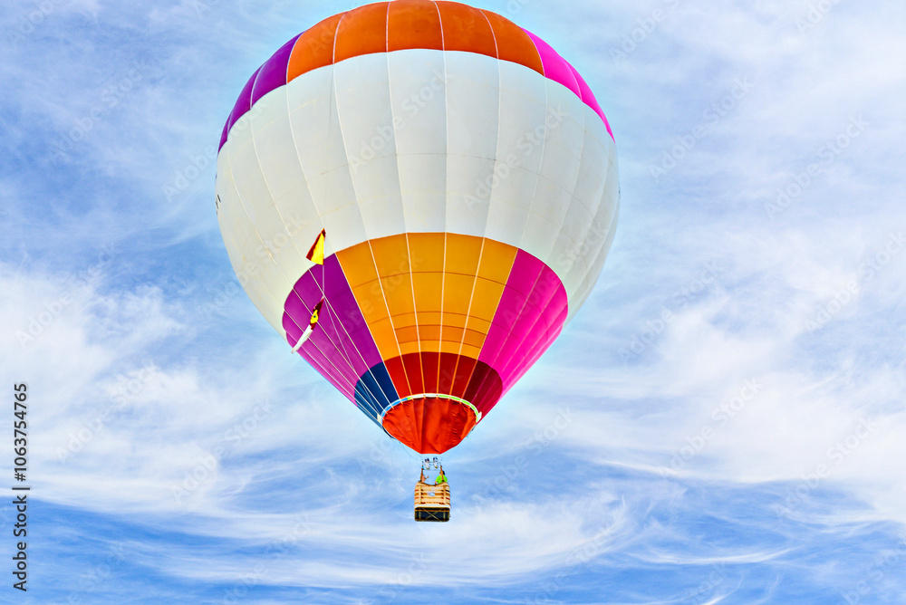 Naklejka premium Colorful hot air balloon flying over blue sky with white clouds 