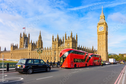 Double-decker buses and black cab on Westminster bridge with Big Ben and Houses of Parliament at background, London, UK