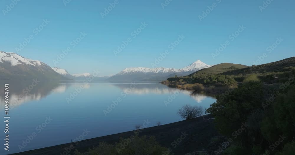 Zoom in on the peaceful waters of Lake Huechulafquen at Golden hour. In the distance you can see the Lanin volcano. Patagonia Argentina Zoom in on the peaceful waters of Lake Huechulafquen at Golden hour. In the distance you can see the Lanin volcano. Patagonia Argentina