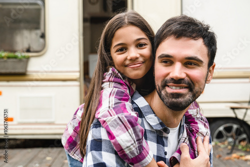 Happy father`s day! Cheerful caucasian single father and preteen daughter looking at camera hugging while traveling by trailer motor camper wheel home, caravanning on holiday