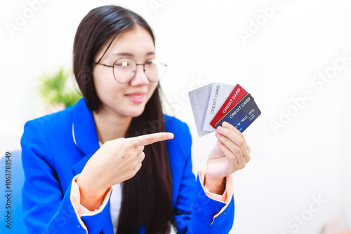 An Asian woman sits at her desk, surrounded by files , embodying dedication and professionalism in her work.