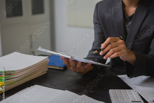 An Asian man works late at his desk papers, determined to meet his deadlines.