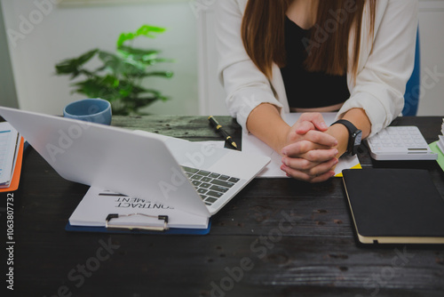 Asian businesswoman, focused , sits at ablack wooden table. Surrounded by notes , she strategizes her next move, embodying confidence and professionalism in her workspace. photo