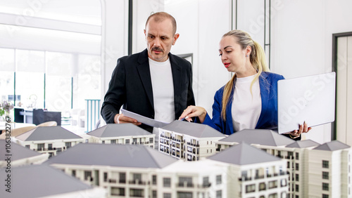 A real estate manager in the office shows the layout of the apartment and advises the client on purchase, rental and mortgage issues. Concept of buying or renting real estate. photo