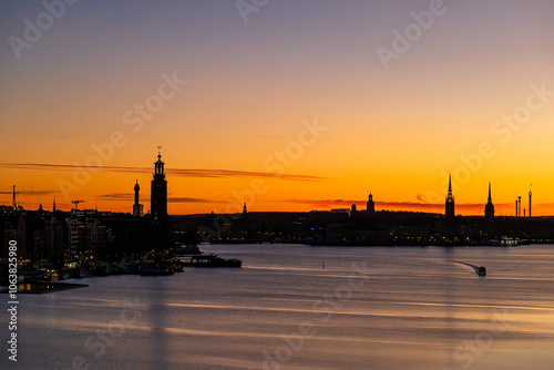 Photography Stockholm, Sweden A boat in the early morning and a skyline silhouette of the city with the City Hall