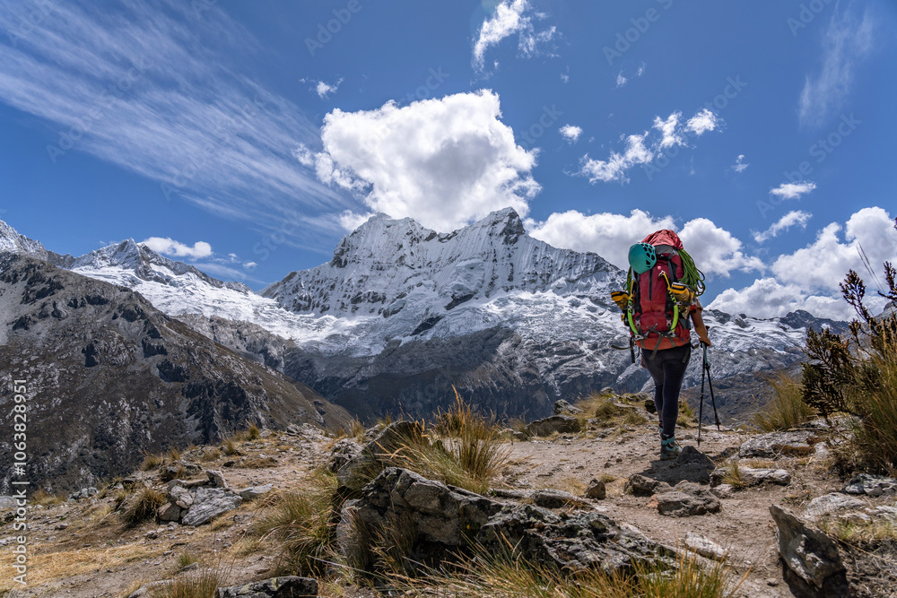 woman walks with a backpack in the middle of a mountainous landscape with snowy peaks in the background of the landscape and carrying technical mountaineering and with style and strength in her life woman walks with a backpack in the middle of a mountainous landscape with snowy peaks in the background of the landscape and carrying technical mountaineering and with style and strength in her life