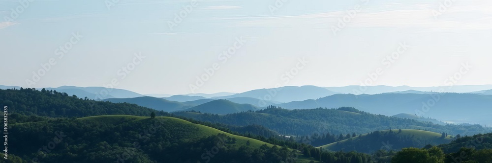 Fototapeta premium A beautiful landscape of rolling hills covered in lush green trees under a clear blue sky, scenery, blue