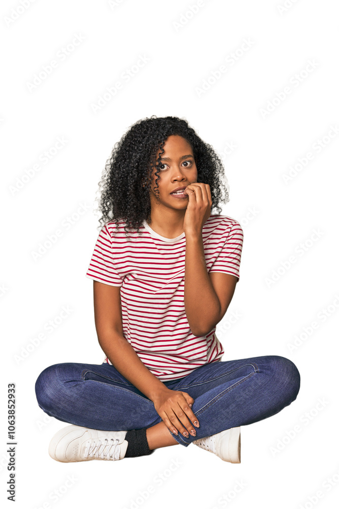 oung woman sitting on floor in studio biting fingernails, nervous and very anxious. oung woman sitting on floor in studio biting fingernails, nervous and very anxious.