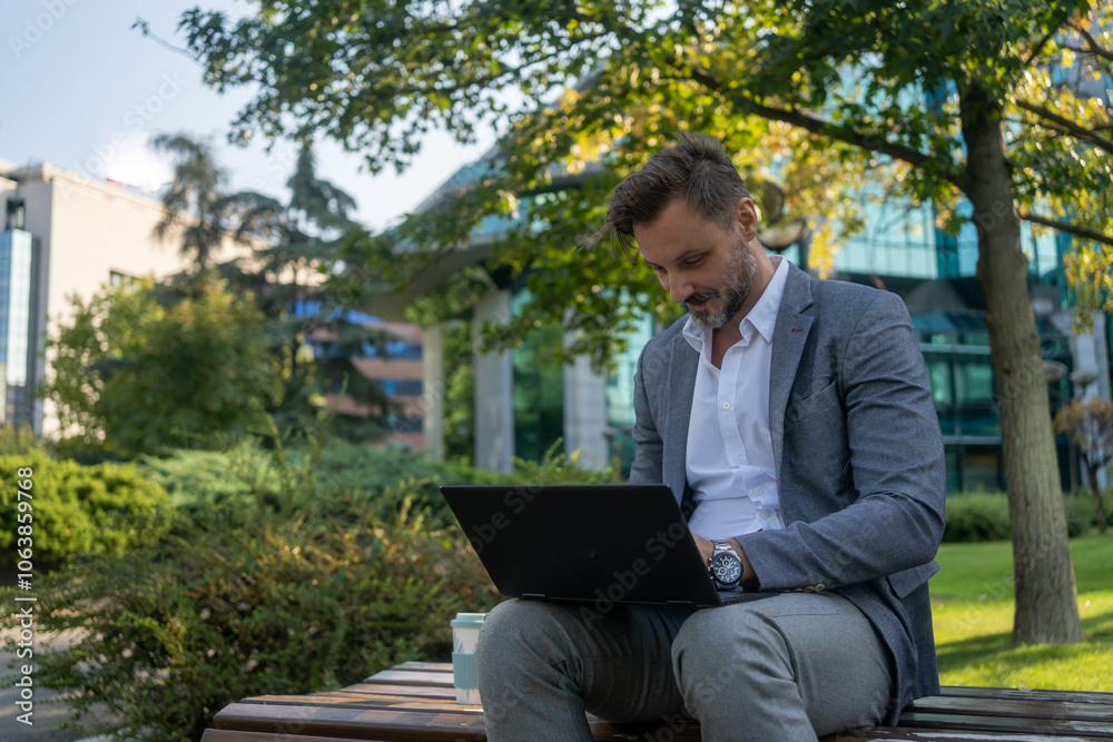 Portrait of young smiling cheerful entrepreneur in casual office making phone call while working with laptop Portrait of young smiling cheerful entrepreneur in casual office making phone call while working with laptop