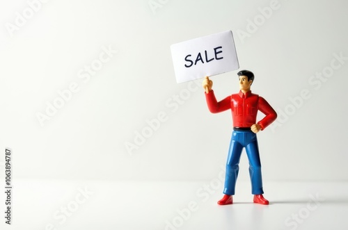 toy man holding a sign with the text (Sale)