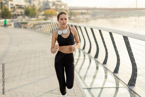 Young woman jogs along a mo...