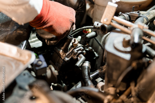 Car Mechanic Working on Fuel Injector in Engine Compartment