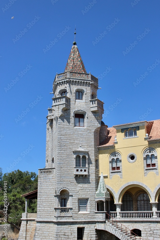 Fototapeta premium Cascais, Portugal - August 16 2016: Charming Stone Tower of Palace of Counts of Castro Guimaraes Under Clear Blue Sky
