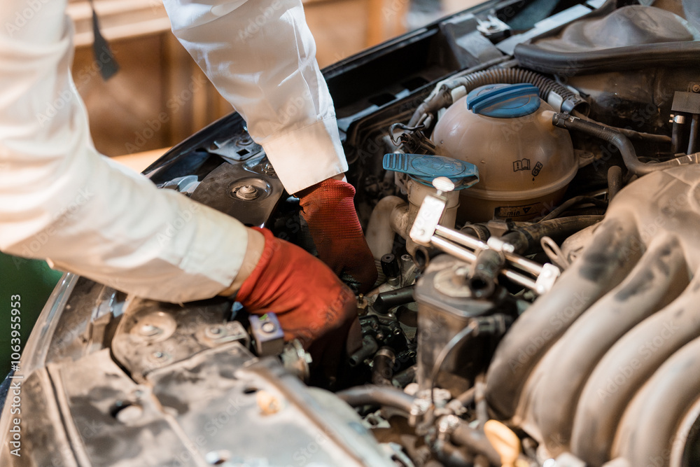 Obraz premium Car Mechanic Working on Engine Components Under Hood
