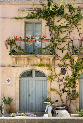 charming old italian building with climbing plants and scooter