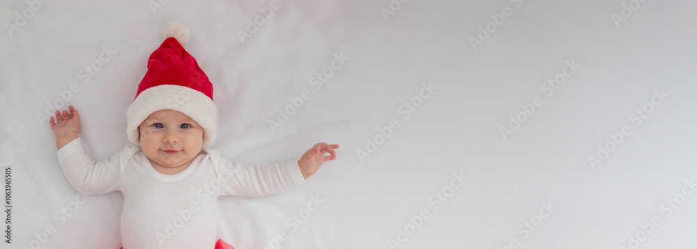 Baby girl in a Santa hat on a light background.holiday. Baby girl in a Santa hat on a light background.holiday.