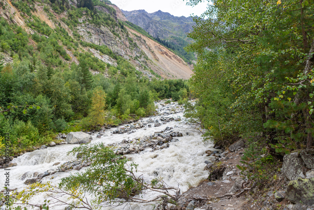 Stormy flow of a mountain mestiachala river. Active recreation and hiking. Gloomy rainy weather. Beginning of the route to Chalaadi Glacier Georgia