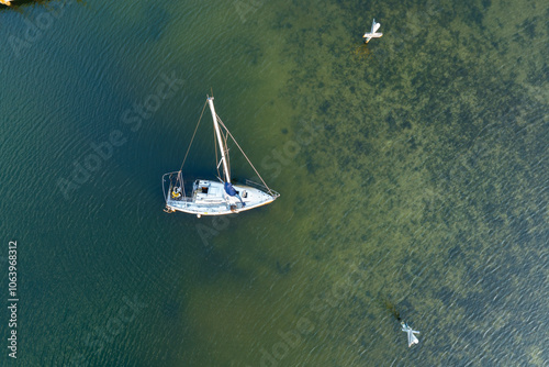 Aerial view of sunken sailboat on shallow bay waters after hurricane in Manasota, Florida photo