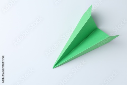 One handmade green paper plane on white background, top view. Space for text