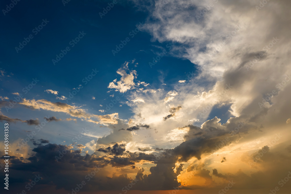Bright sunset with setting sun behind vivid orange and yellow clouds