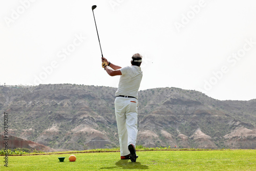 The golfer hits the golf ball with the Drive in his hand, on the tee.