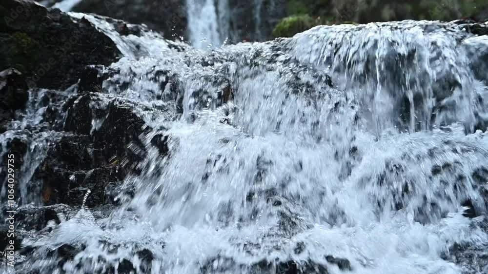 Closeup of a waterfall in an autum forest, water flowing over rocks, slow motion Closeup of a waterfall in an autum forest, water flowing over rocks, slow motion