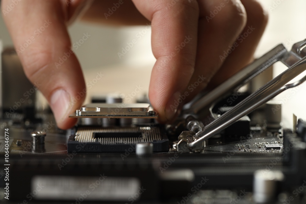 Man installing computer chip onto motherboard at table, closeup Man installing computer chip onto motherboard at table, closeup