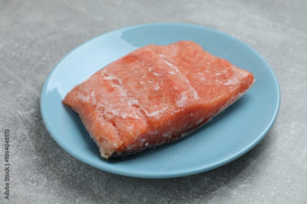 Frozen piece of salmon on grey table, closeup Frozen piece of salmon on grey table, closeup