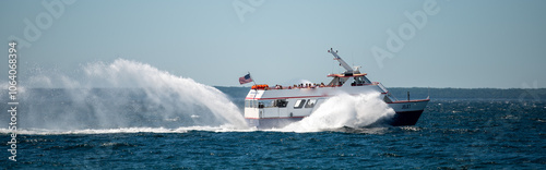 ferry sailing from mackinac island with high speed splashing water photo