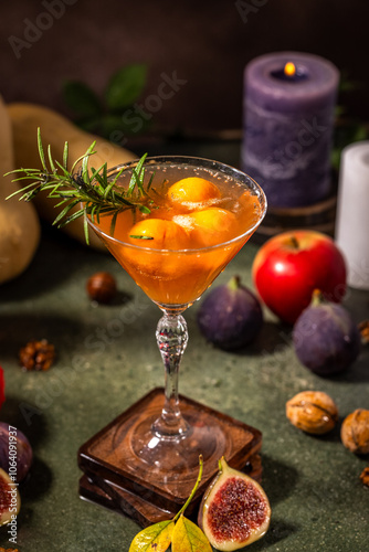 Elegant fall cocktail decorated with rosemary in martini glass photo