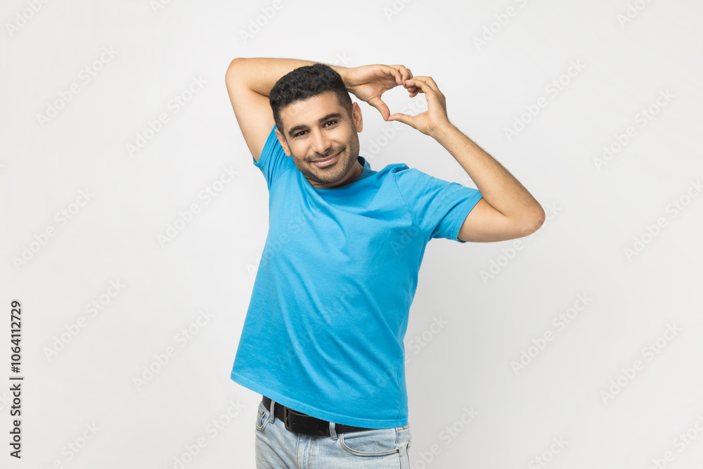 Man shapes heart gesture above head, prepares for Valentines day, expresses affection and adornment. Man shapes heart gesture above head, prepares for Valentines day, expresses affection and adornment.