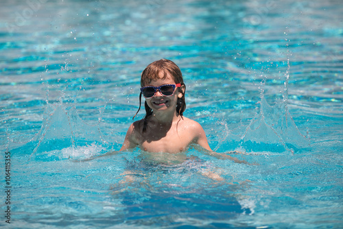 Excited child boy in sunglasses in pool in summer day. Cute child boy swim in swimming pool, summer water background with copy space. Funny kids face.