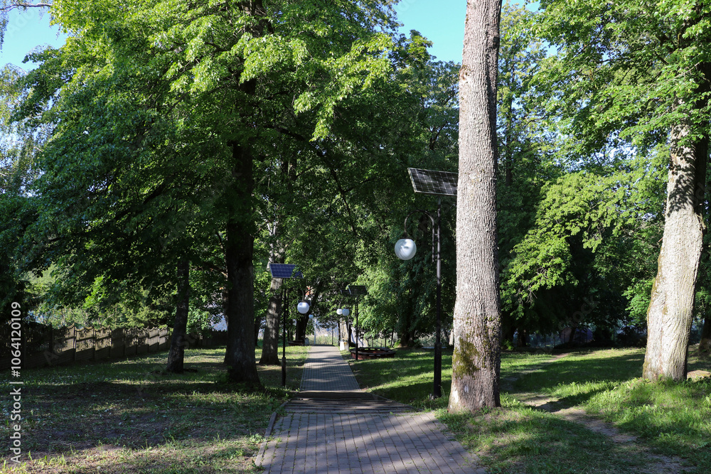 Solar lamps installed on the avenue among trees Solar lamps installed on the avenue among trees