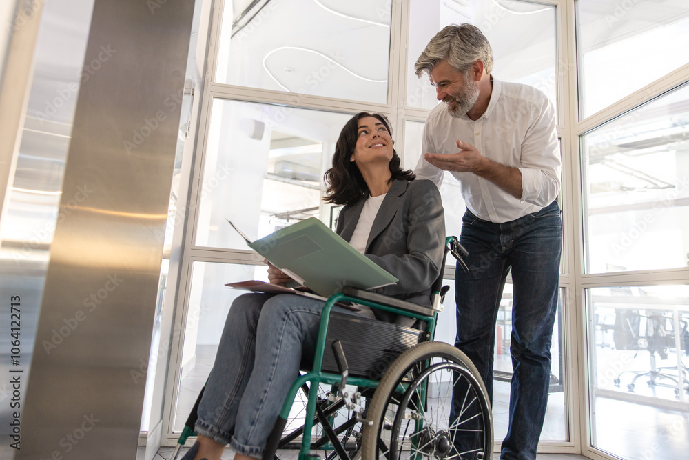 Man with disabled colleague standing at the elevator for inclusion Man with disabled colleague standing at the elevator for inclusion