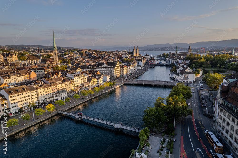 Fototapeta premium Beautiful aerial view of the city of Zurich in Switzerland - the Limmat River and its iconic churches, buildings rivers and Clockes.