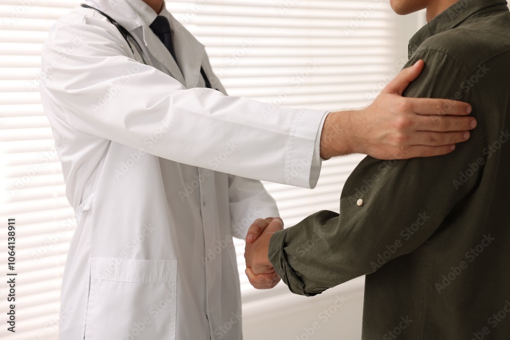 Doctor shaking hands with patient in hospital, closeup Doctor shaking hands with patient in hospital, closeup