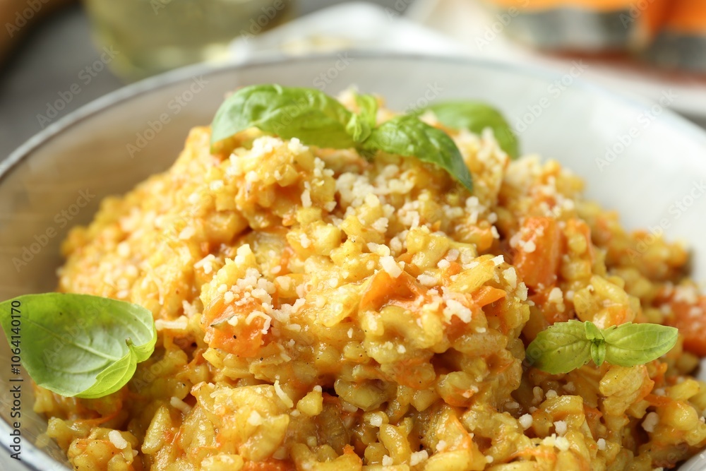 Delicious pumpkin risotto with basil on table, closeup Delicious pumpkin risotto with basil on table, closeup