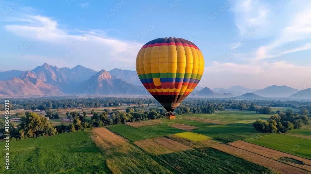 Naklejka premium Vibrant Hot Air Balloon Over Scenic Landscape