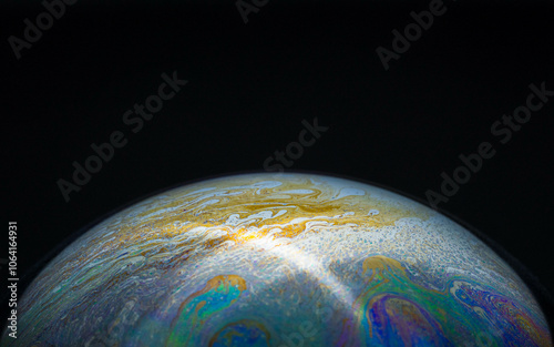 drawing of the earth with a bright flash ray on a hemisphere in a soap bubble on a black background, empty space for an inscription, ecology