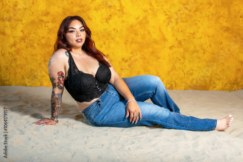 woman sitting on sand in blue denim