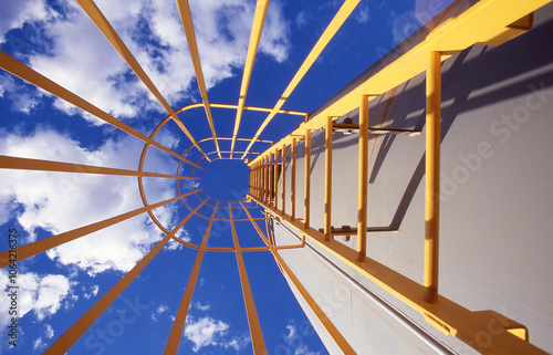 Looking up the inside of an enclosed industrial ladder