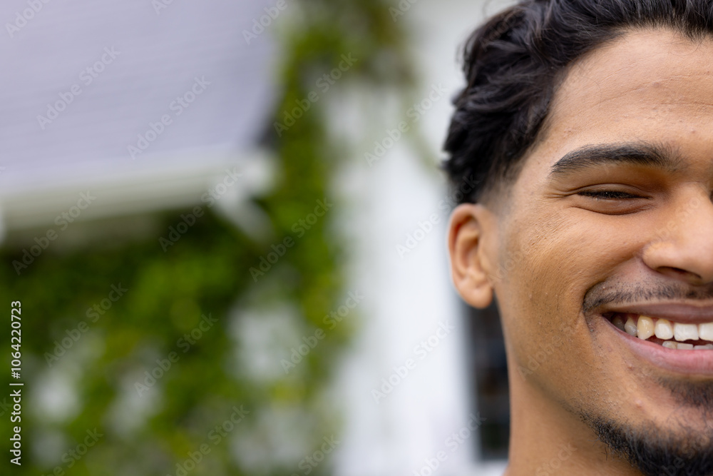 At holiday gathering, man smiling with multiracial friends outdoors, having fun together, copy space