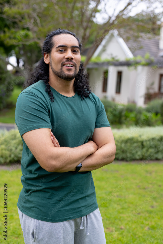 Smiling young man standing confidently in garden, enjoying outdoor relaxation Smiling young man standing confidently in garden, enjoying outdoor relaxation