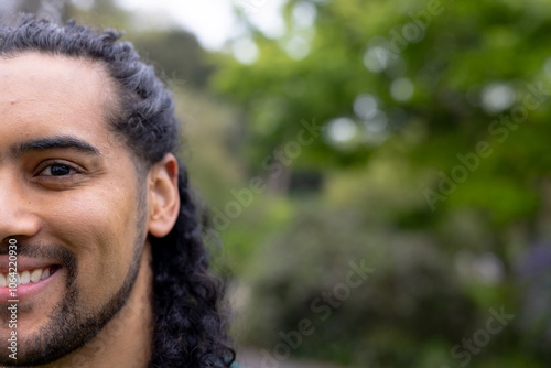 Smiling young man enjoying nature in lush green park setting, copy space