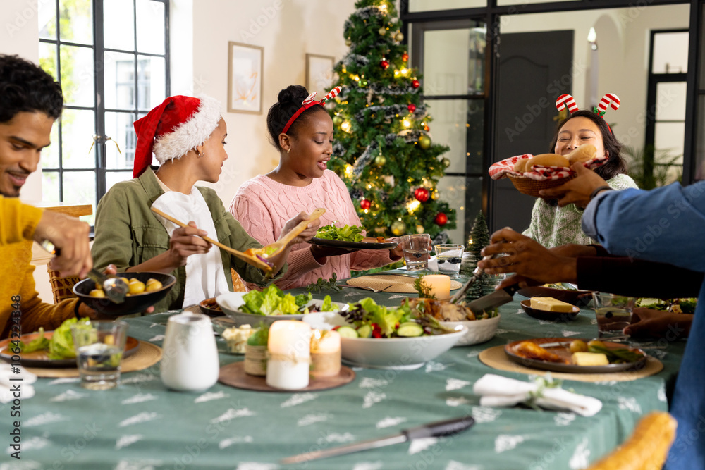 Young multiracial friends enjoying festive christmas dinner together, at home Young multiracial friends enjoying festive christmas dinner together, at home