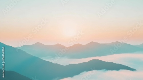 The mountains are covered in a light blue mist and the sun is setting in the distance.