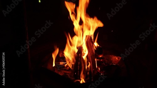 On a dark fall night, a fire is made with firewood in the brazier
